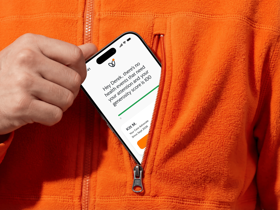 The reimagined app on a phone, slipping into an orange fleece pocket